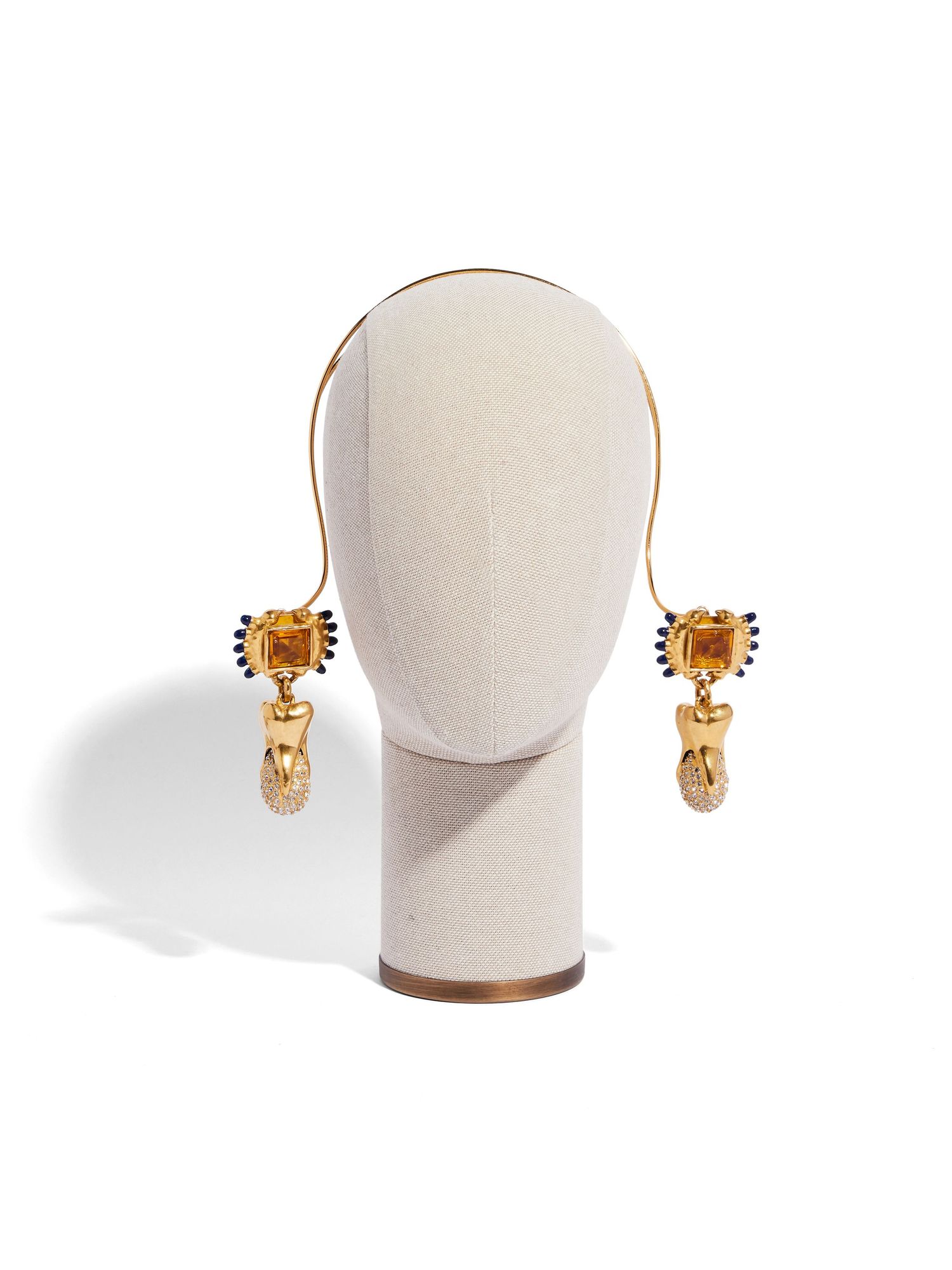 Gold dangle earrings displayed on a white mannequin head bust against white background.