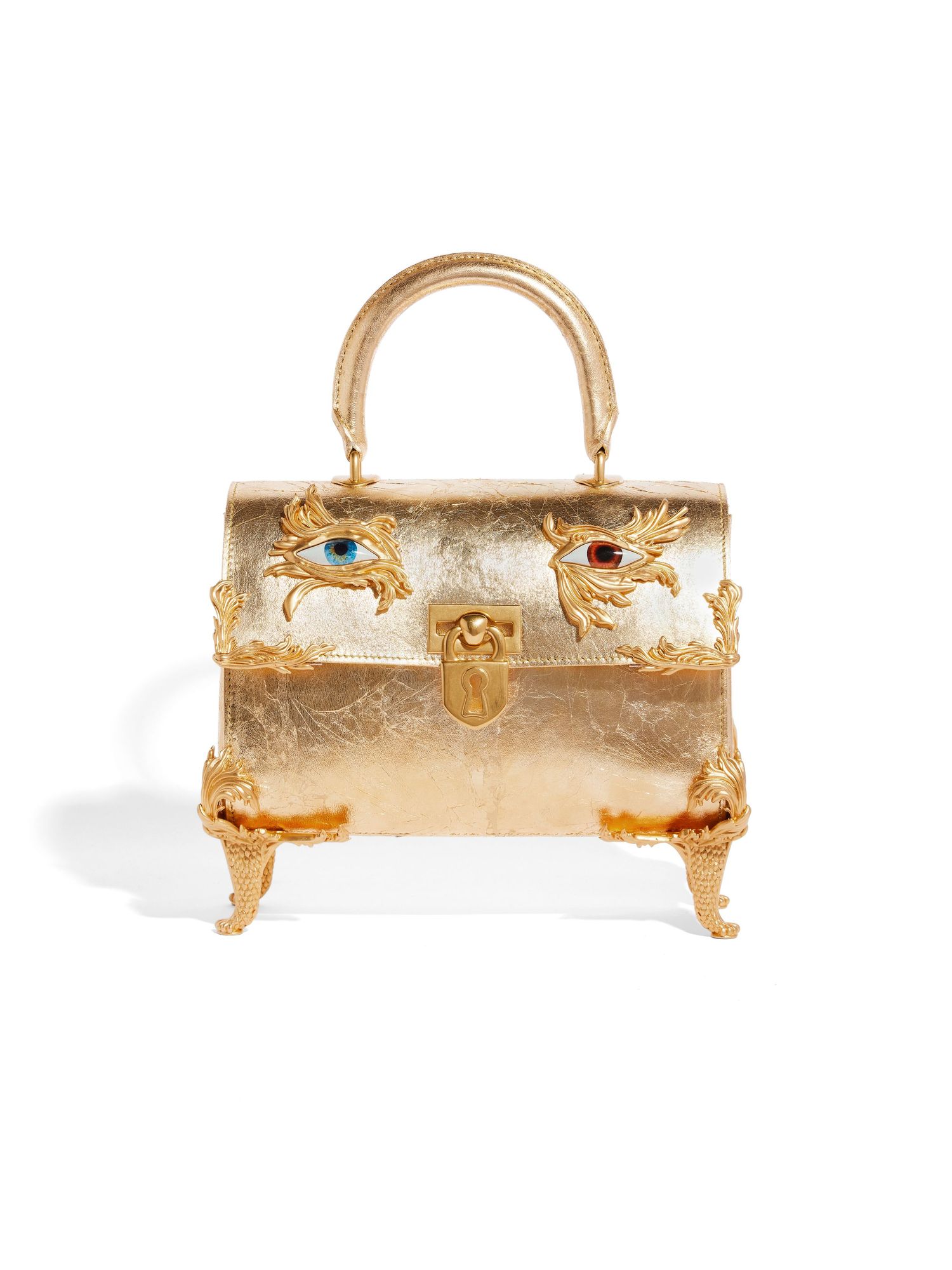 Gold metallic structured handbag with whimsical face design and crystal-embellished eyes.