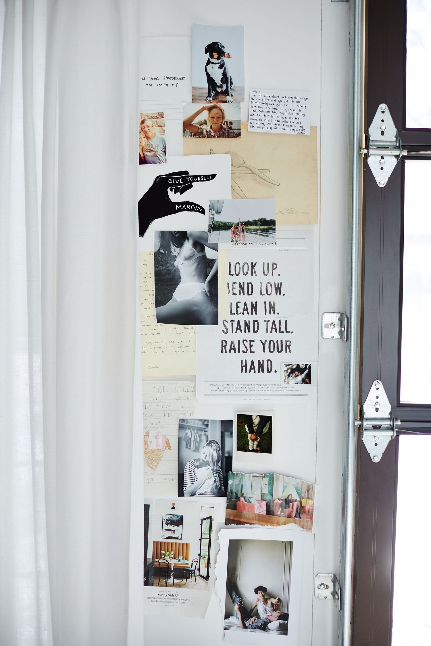 White wall decorated with various black and white photographs and inspirational text posters.