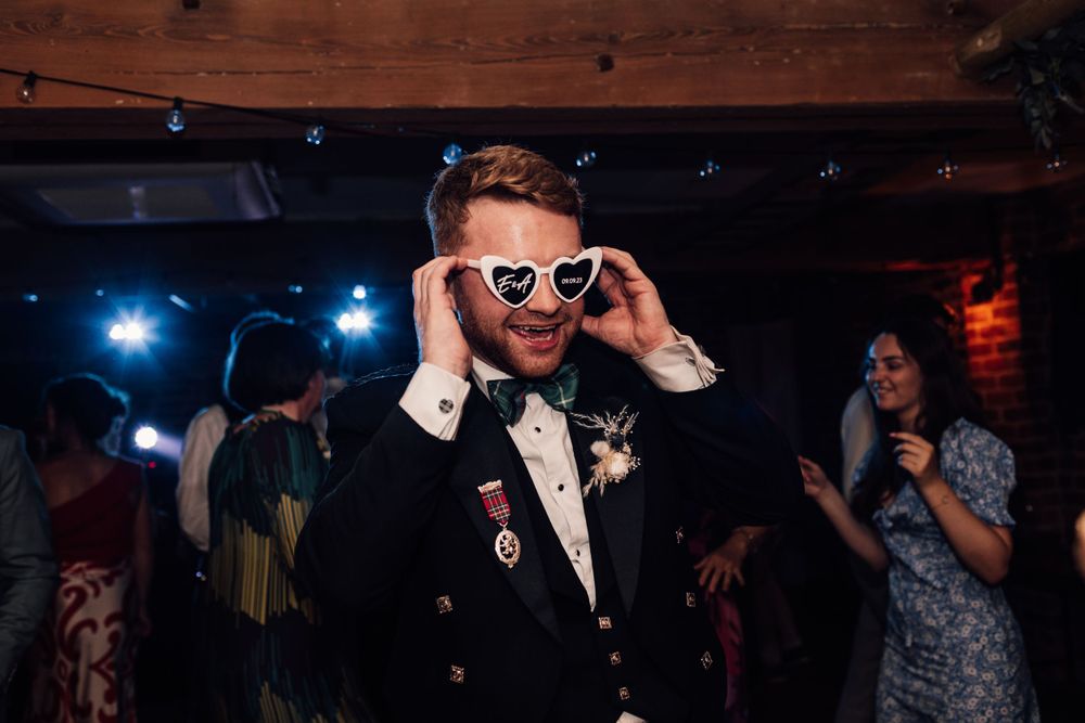 groom on dancefloor with sunglasses on