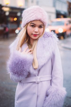 beautiful young Asian woman in lilac coat and ha