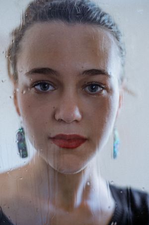 portrait of a young woman through the glass, red lipstick