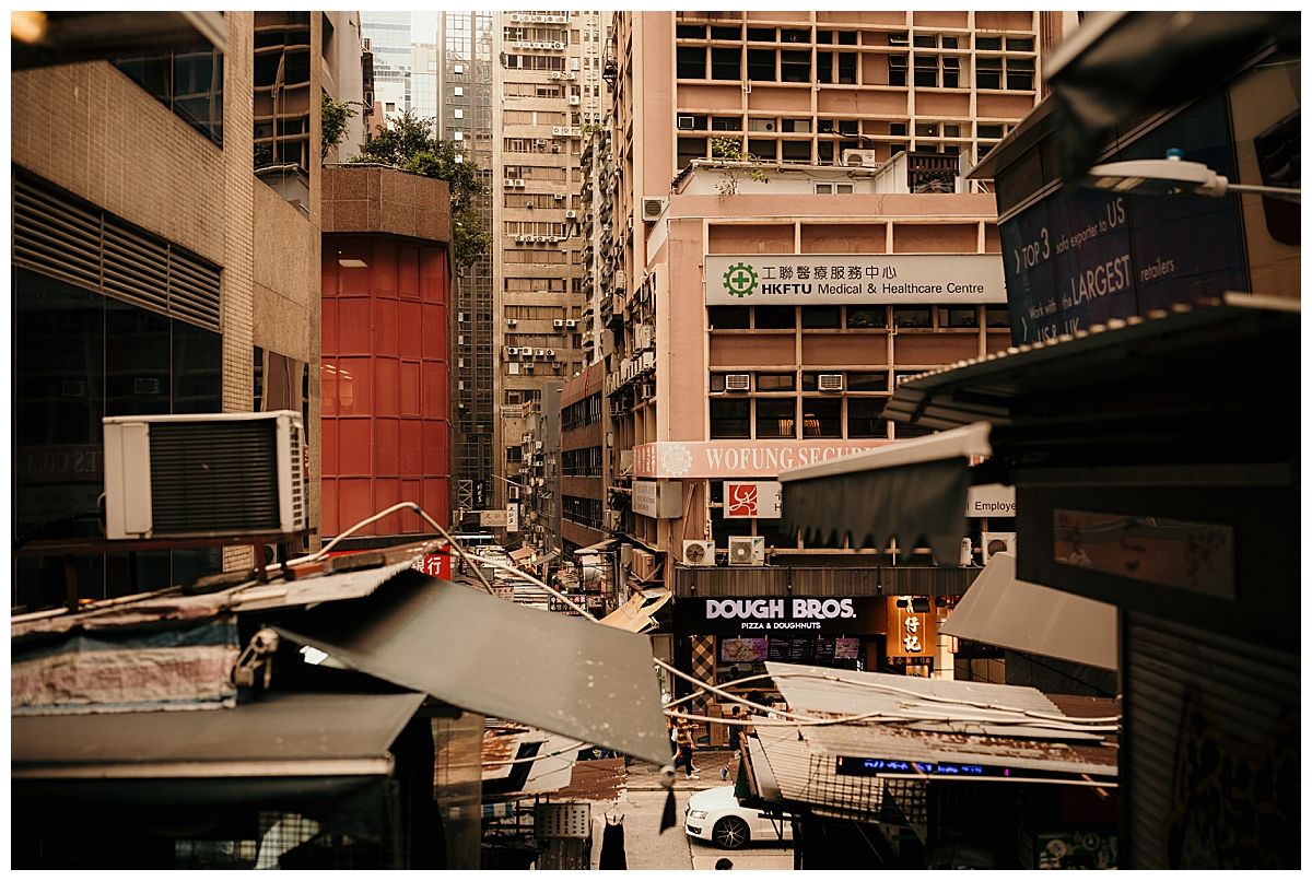 Urban decay in a cramped Hong Kong alleyway with signs and cluttered storefronts.