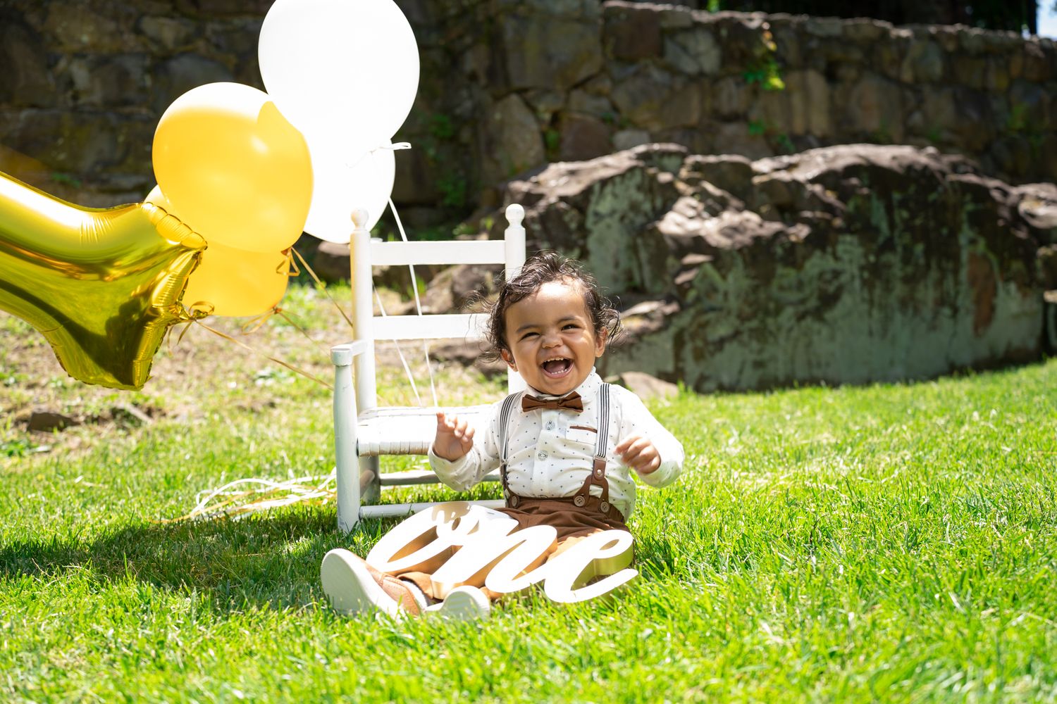 Yellow balloons float in a sunny outdoor setting during a celebration.