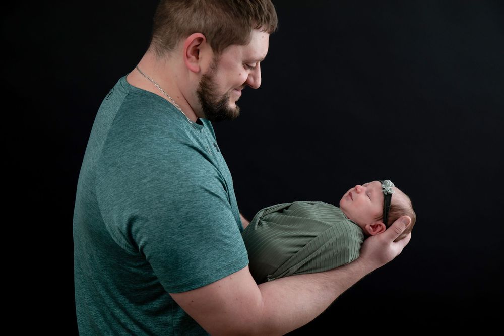 Tender parent-child moment captured against dark background showing joyful connection.