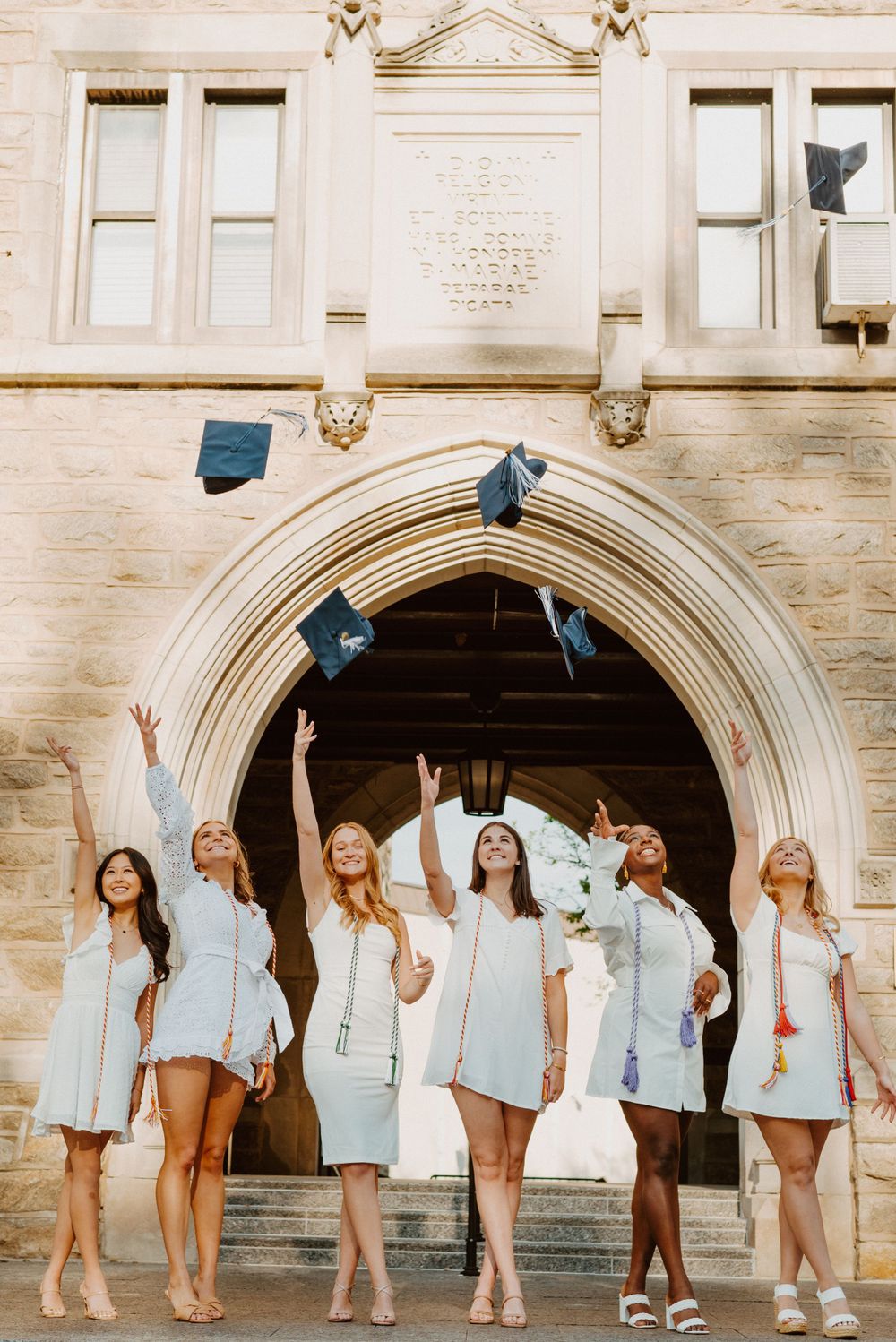 Graduates toss caps in front of Corr Chapel Arch at Villanova University