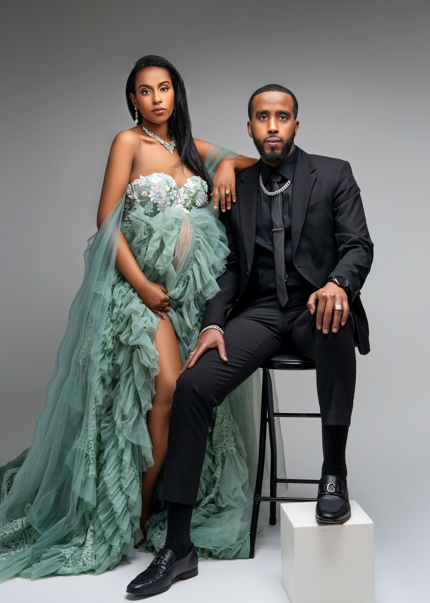 a glamorous expecting couple pose in a studio maternity photo shoot in minneapolis minnesota