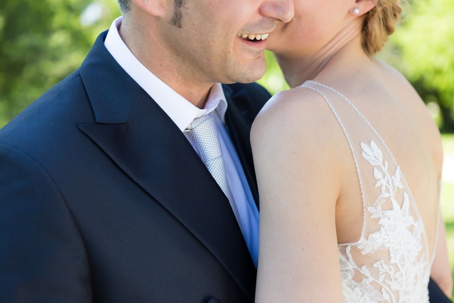 sposi in vestito bianco e blu si avvicinano l'uno all'altra sorridenti