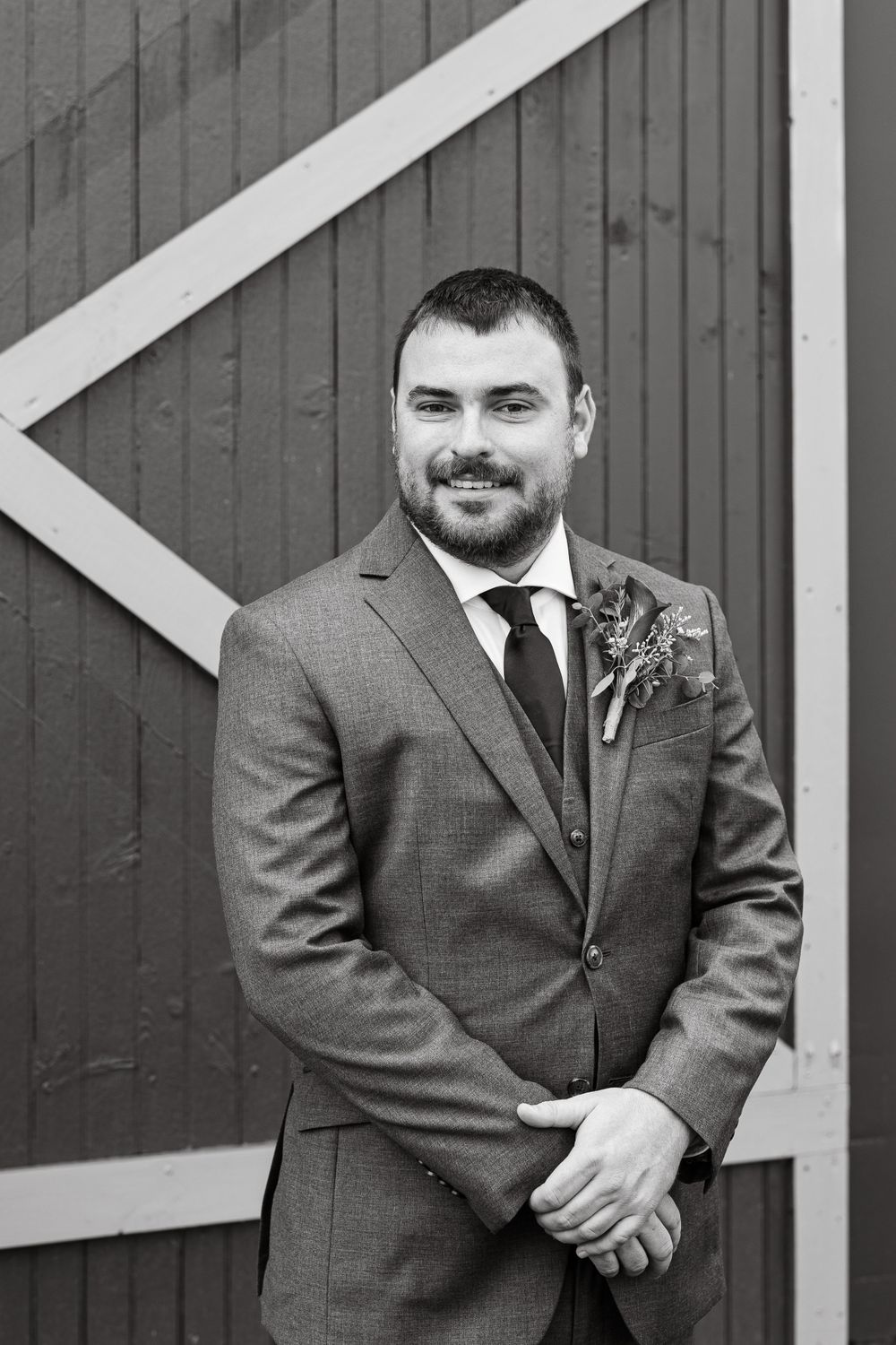 Portrait against a red barn wall with white diagonal trim.