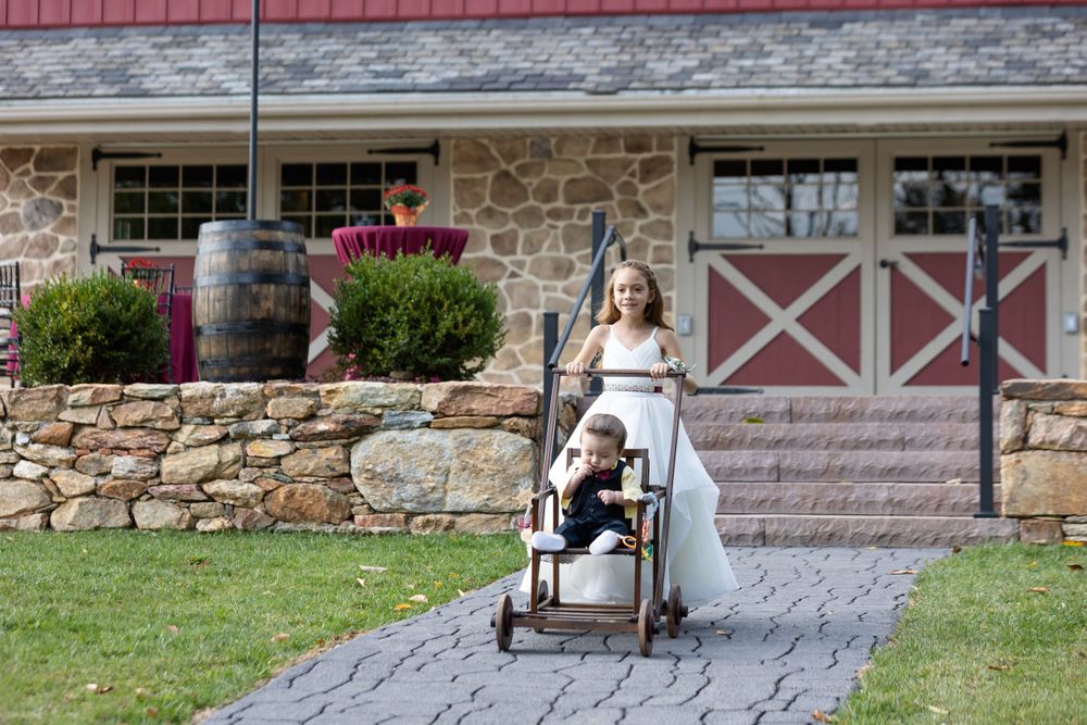 Vintage red barn wedding venue with stone foundation and pathway.