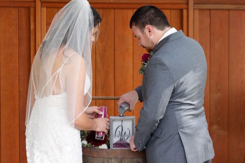 Wedding ceremony moment with couple and wooden decor.