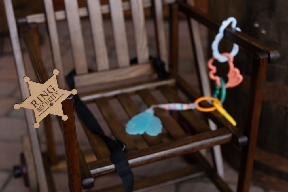 Rustic wooden rocking chair with sheriff star and baby toys.