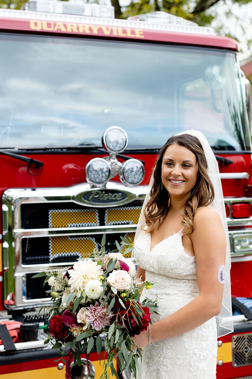 A bride holds a vibrant bouquet while standing in front of a Blairsville fire truck.