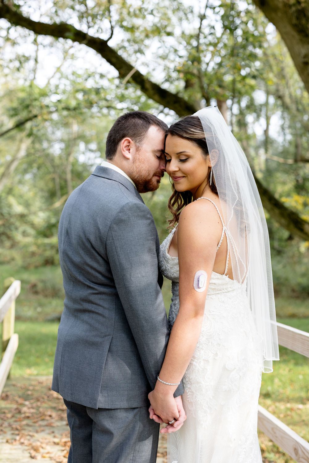 Intimate moment shared on wooden bridge during wedding photoshoot.