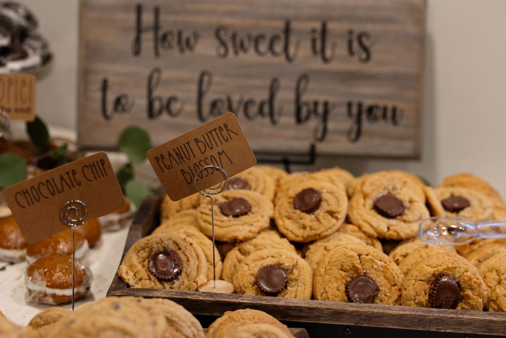 Display of chocolate chip cookies with wooden sign reading 'How sweet it is to be loved by you'.