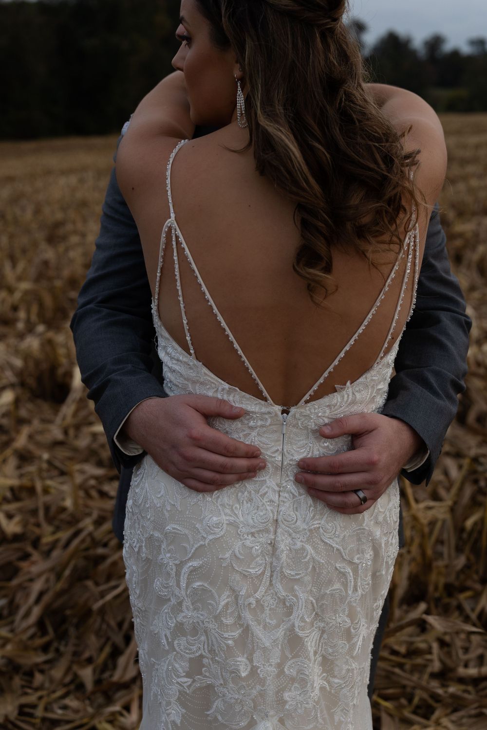 Close-up detail of an intricate beaded wedding dress back with delicate strappy design.