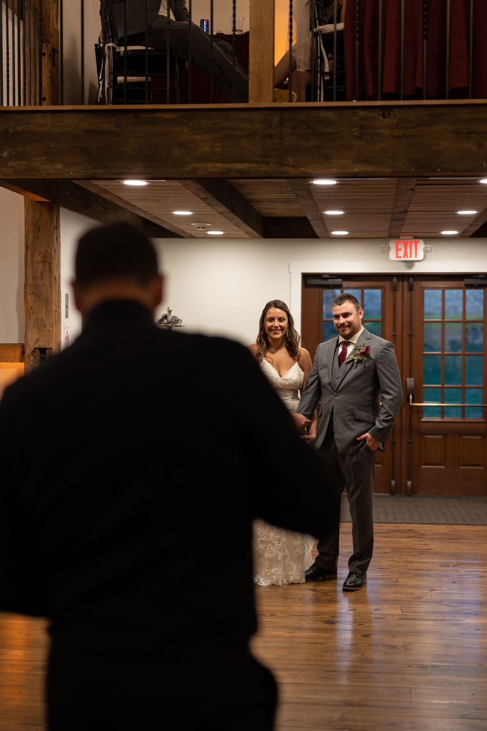 Interior wedding venue shot showing wooden floors and rustic barn architecture.