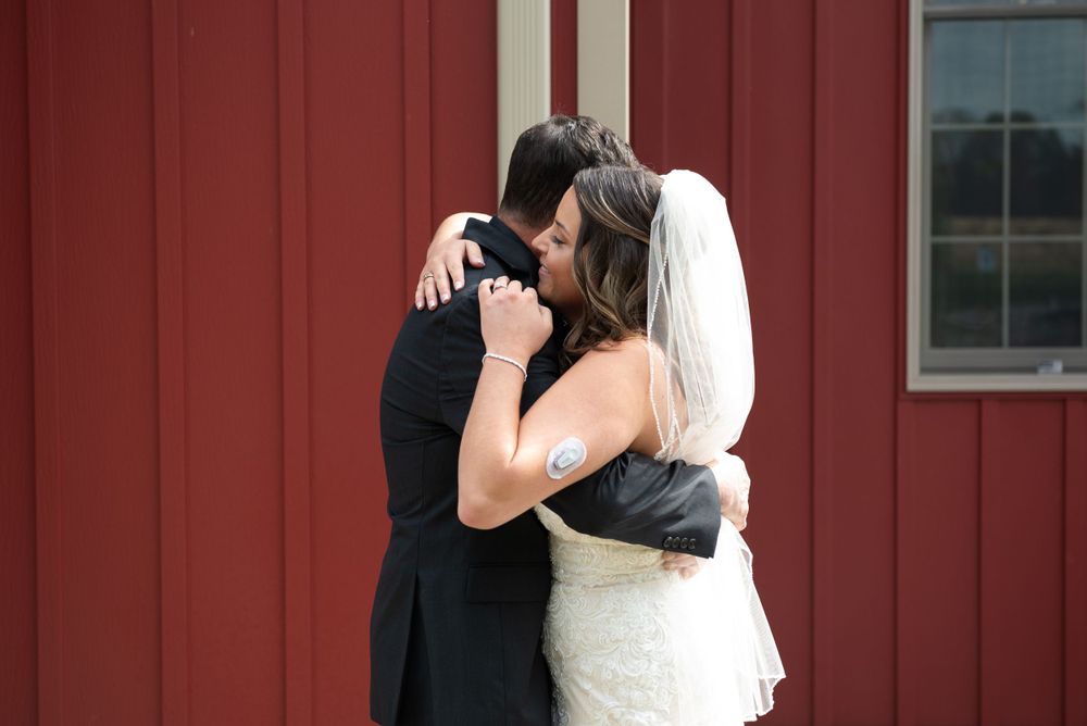 Romantic moment shared between couple against red barn wall backdrop.
