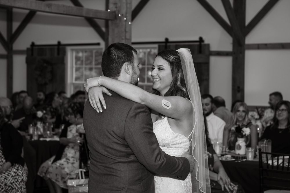 Black and white photo of couple sharing their first dance at wedding reception.