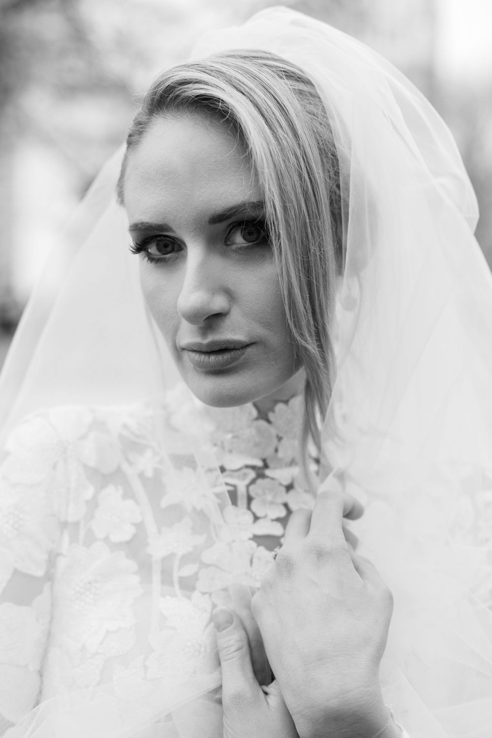Classic black and white bridal portrait featuring delicate lace neckline and ethereal veil.