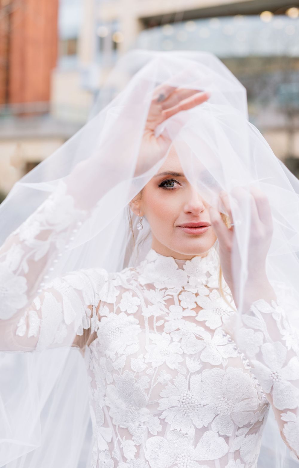 Romantic bridal portrait with sheer veil and high-neck lace wedding dress.