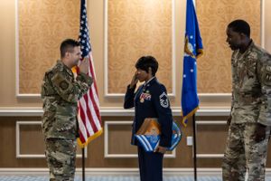 Military personnel and families gather for a formal ceremony in an elegant ballroom setting.