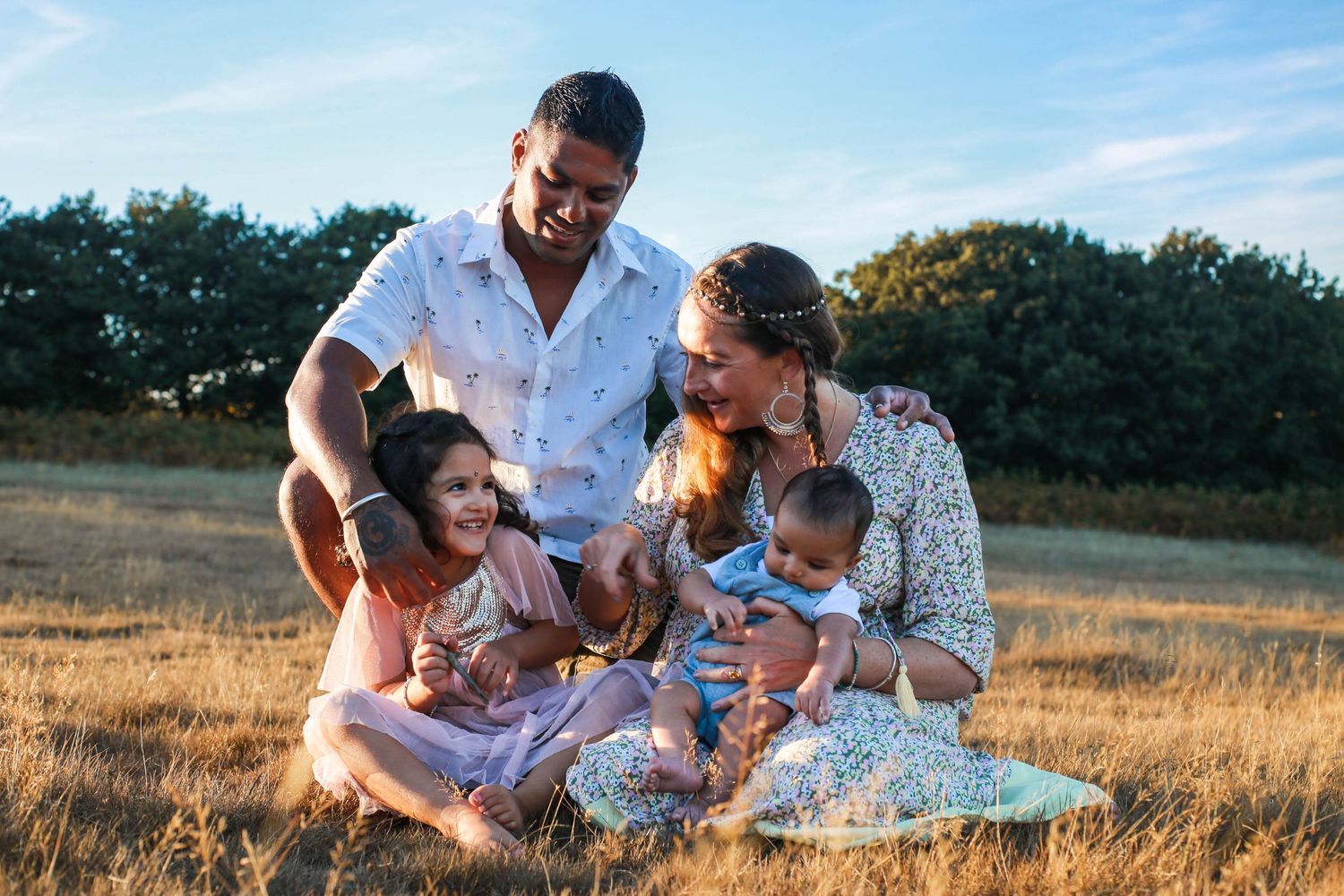 Family enjoying time together in golden field during sunset.