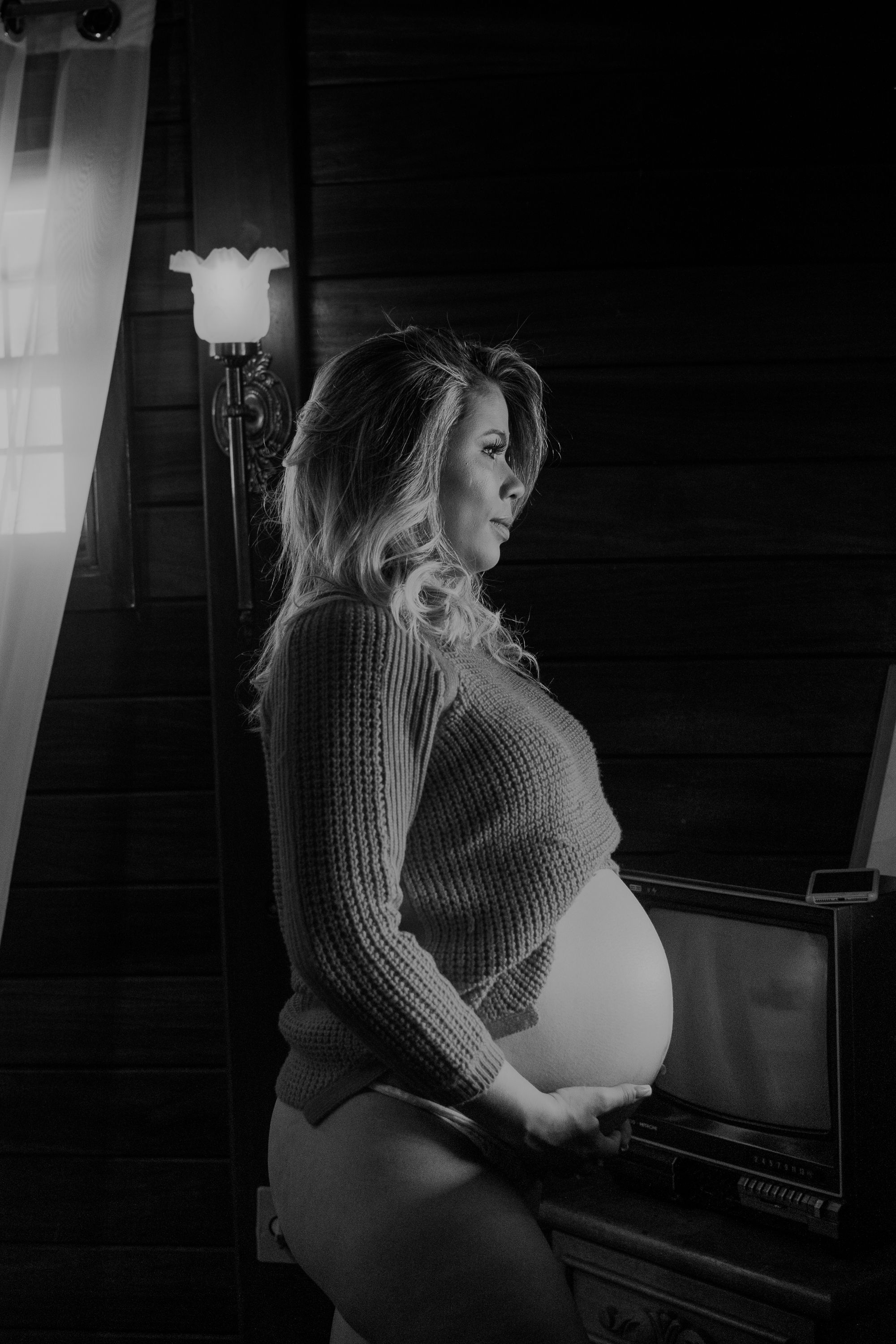 Silhouette maternity photo in black and white near a piano.