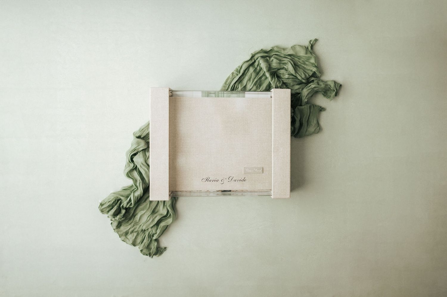 Elegant wooden keepsake box with sage green fabric on a light green background.