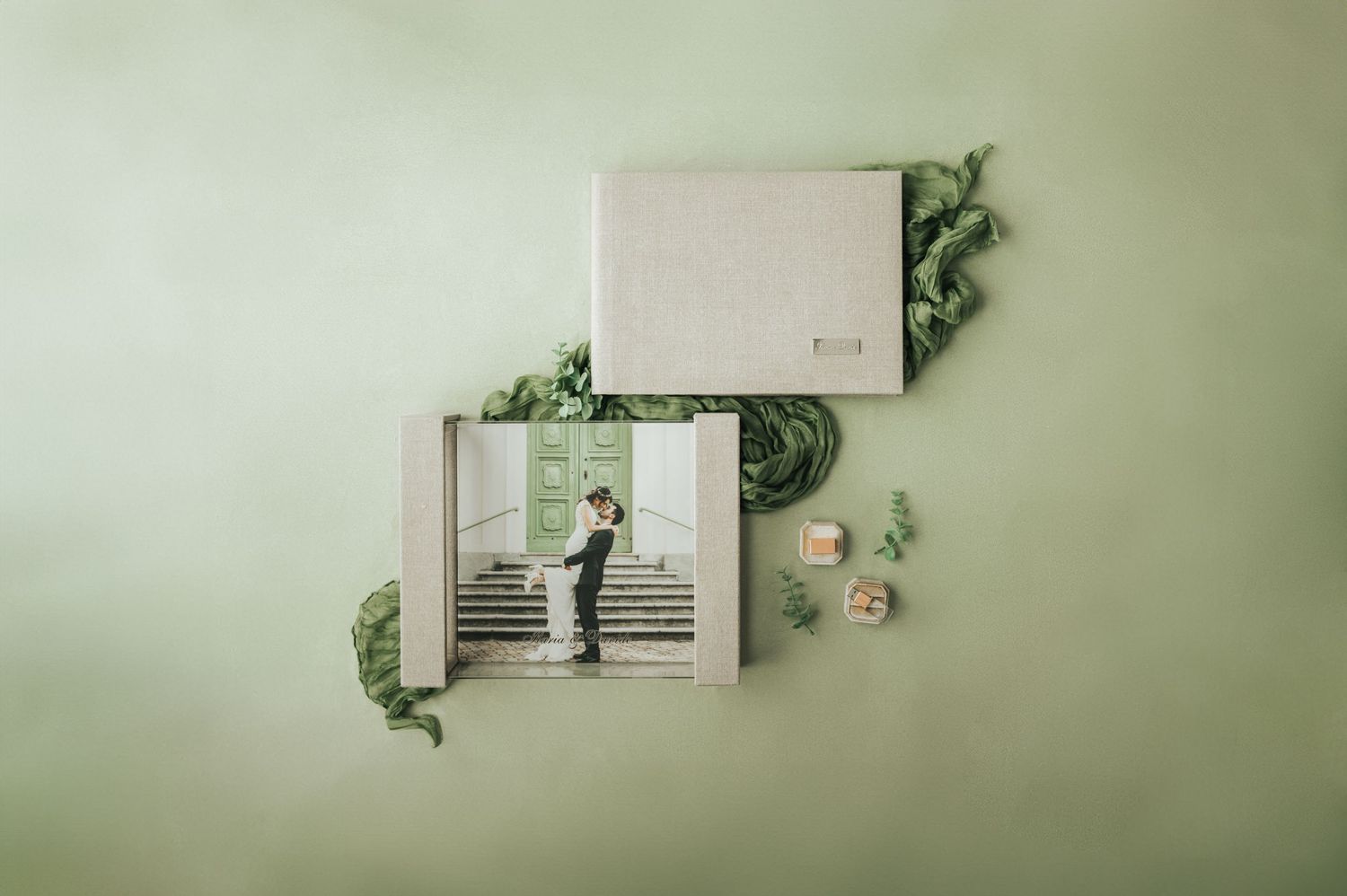 Wedding photo album and keepsake box with couple portrait displayed on a soft green background.