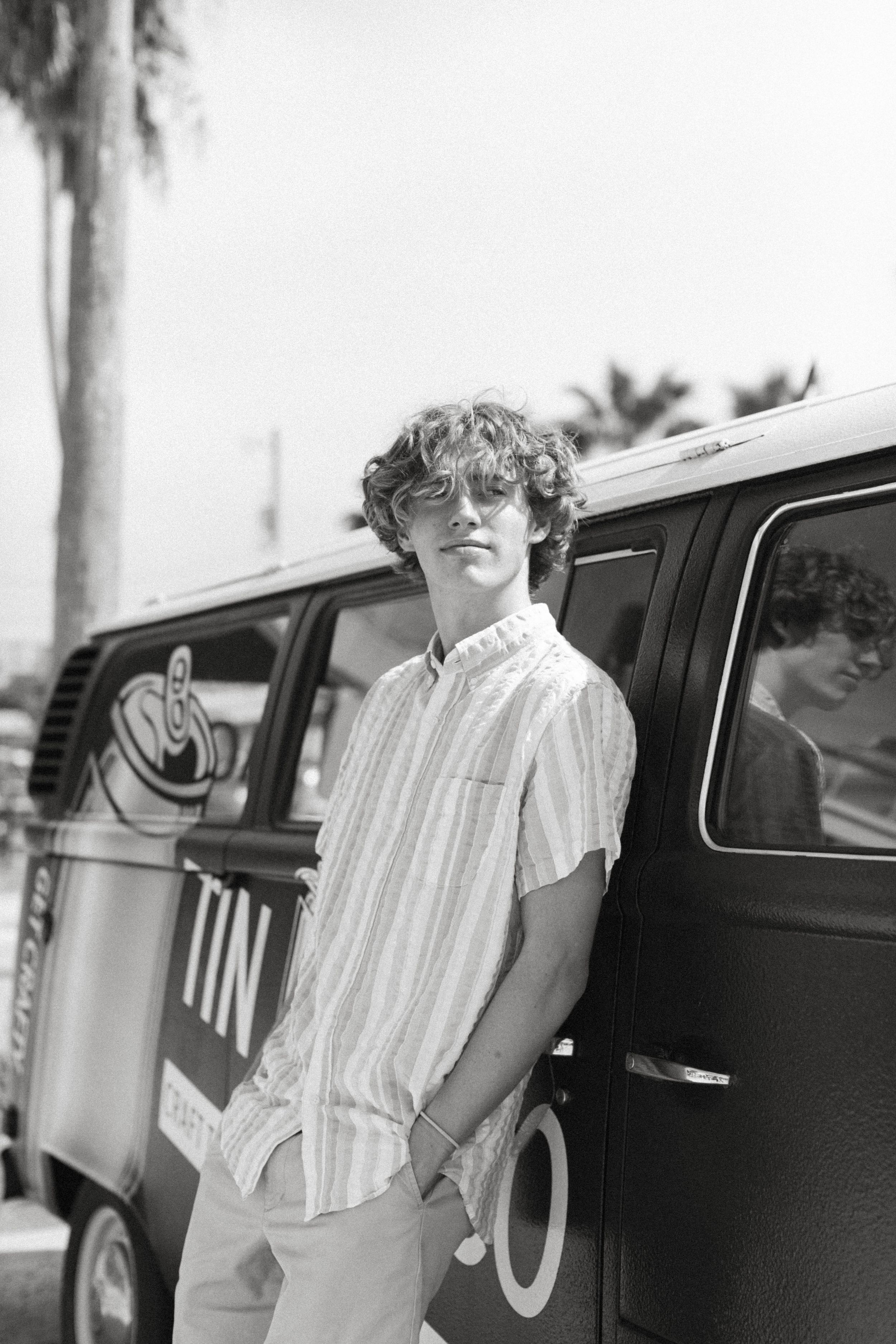 Classic vintage Volkswagen van parked near palm trees in black and white photography.