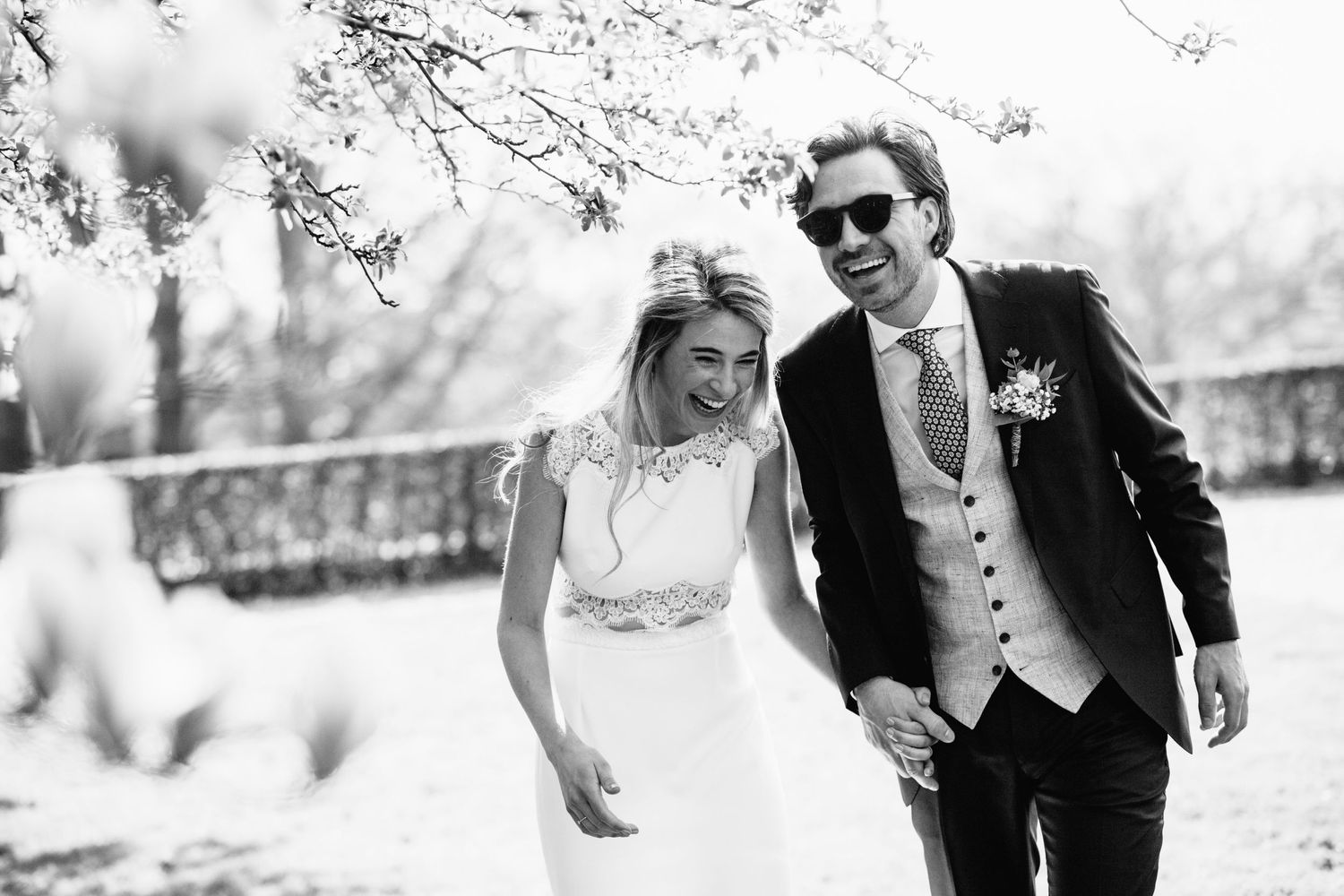 A couple shares a candid moment together outdoors in black and white photography.