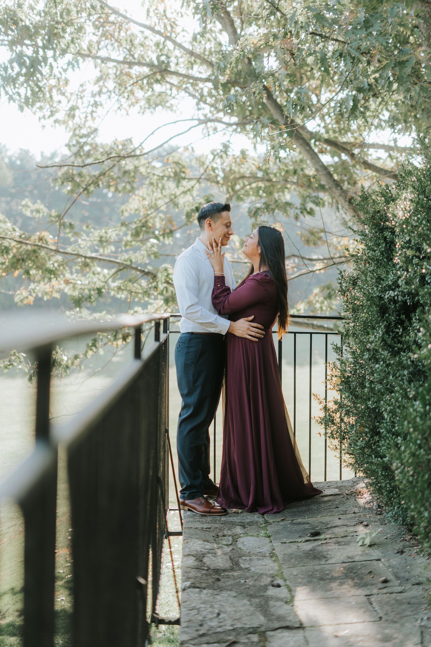 A couple shares an intimate moment on a stone pathway overlooking a scenic vista.