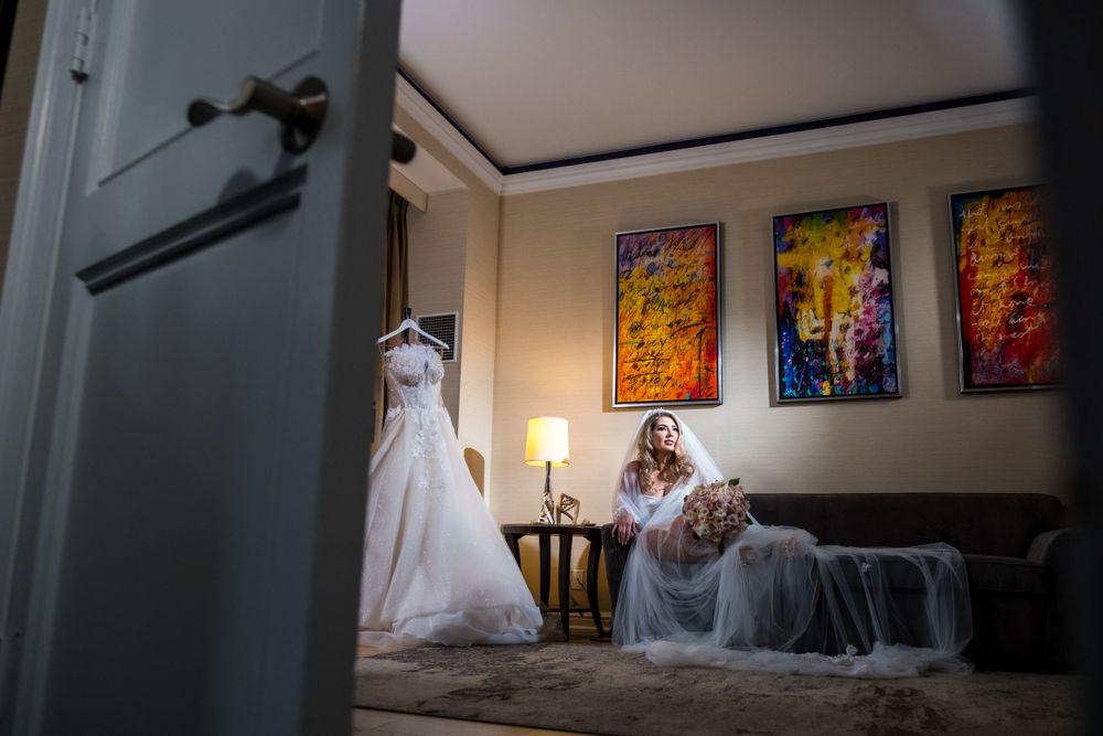 Wedding dress displayed on mannequin in room with colorful artwork and elegant decor.