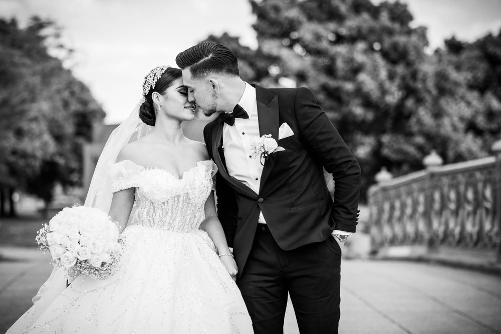 Black and white wedding portrait of a couple sharing an intimate moment outdoors.