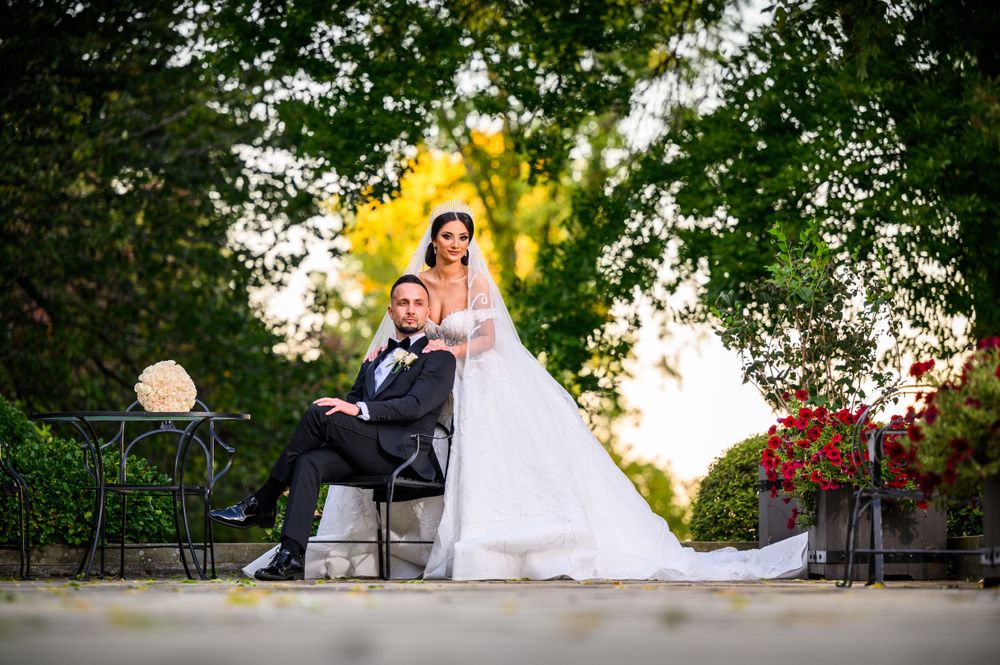 Wedding couple posing in garden setting with beautiful golden sunset lighting.