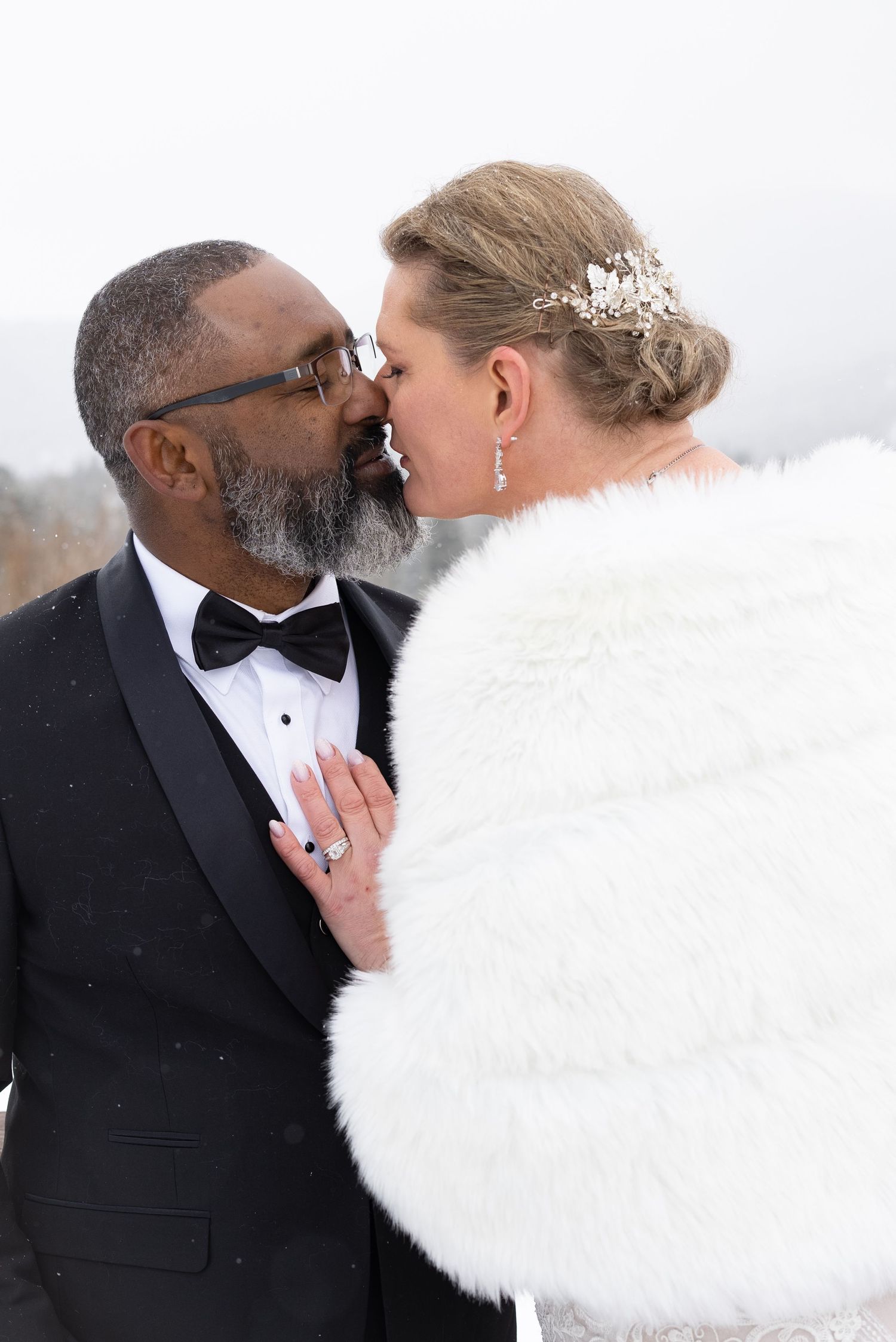 Winter wedding portrait featuring a couple in formal attire with white fur wrap.