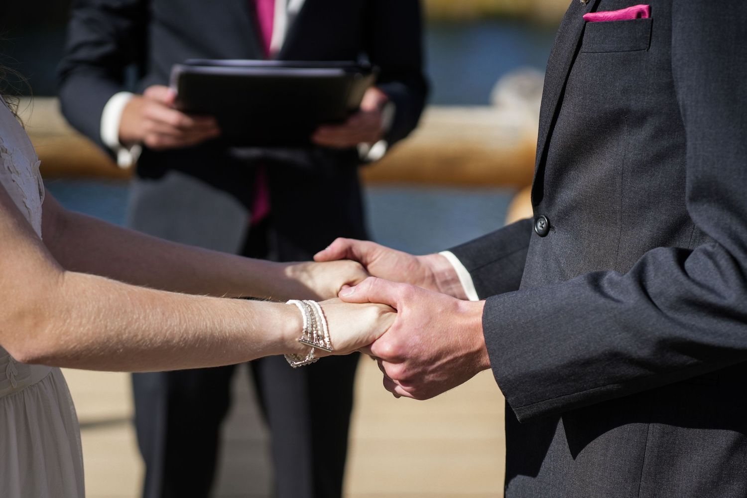 Close-up of hands being held while exchanging vows during a wedding ceremony.
