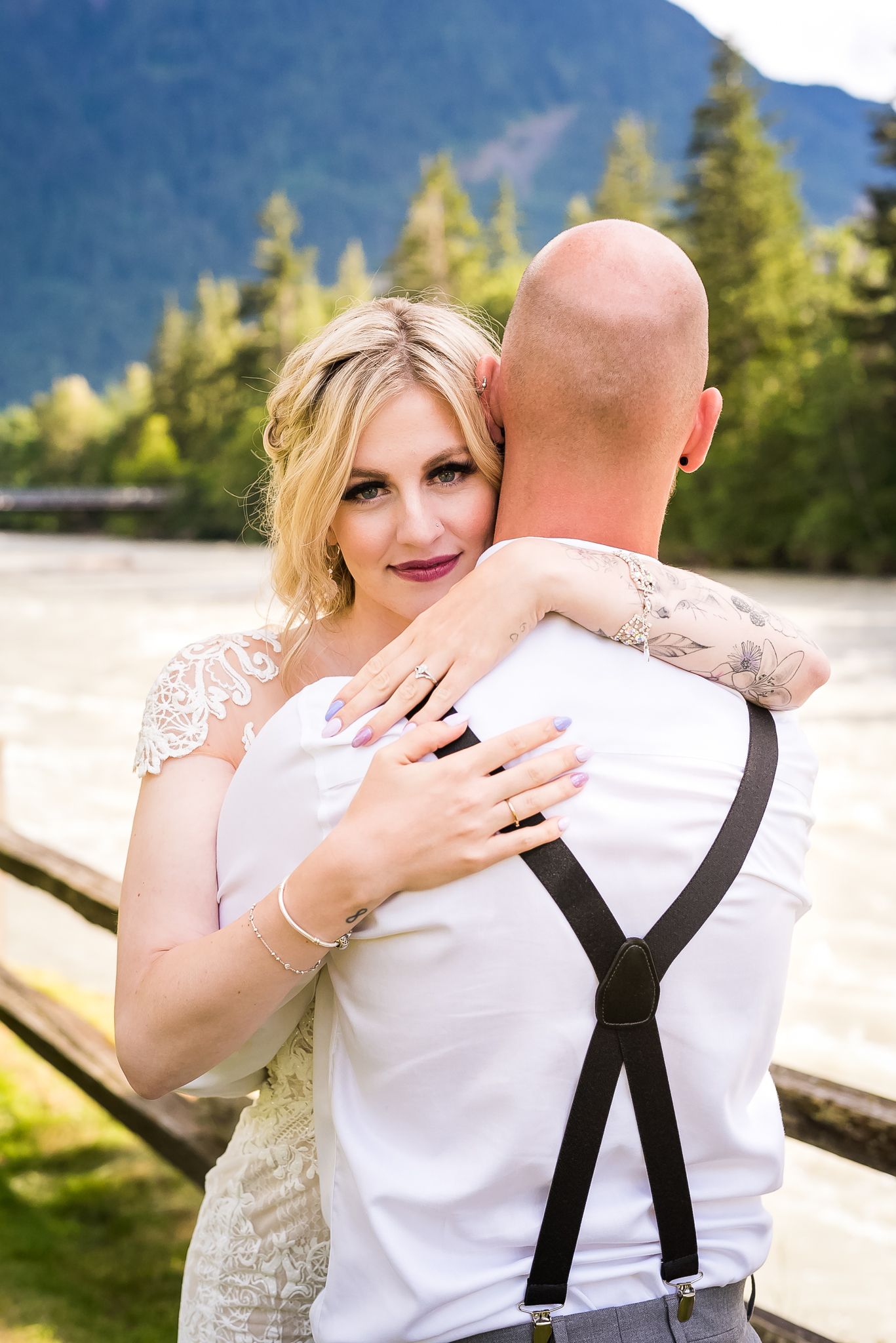 A stunning couple during wedding portraits with a mountain view in Hope. Photo by Kari Mills Photography.