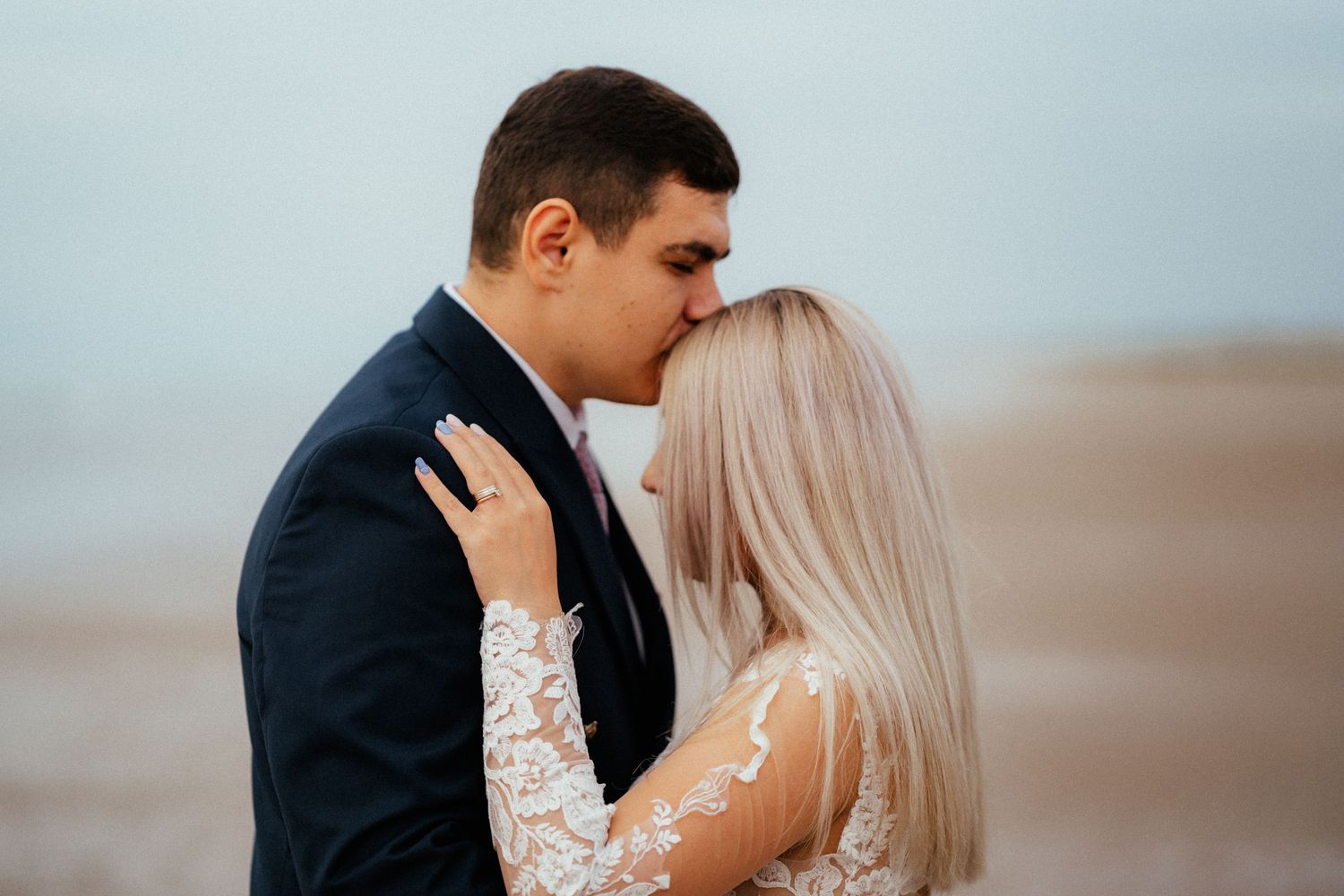 Emotional hug between a bride and her groom on a beach