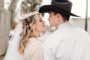 An intimate wedding portrait with traditional western attire and delicate floral crown.