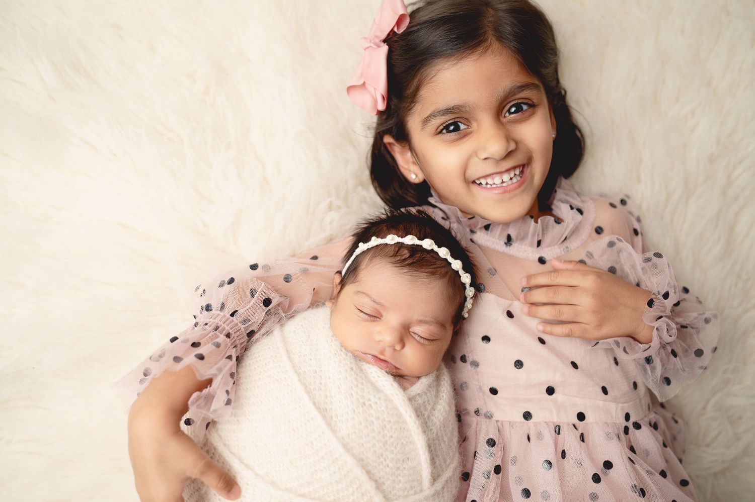 Sweet family moments captured in studio with matching pink polka dot dresses.