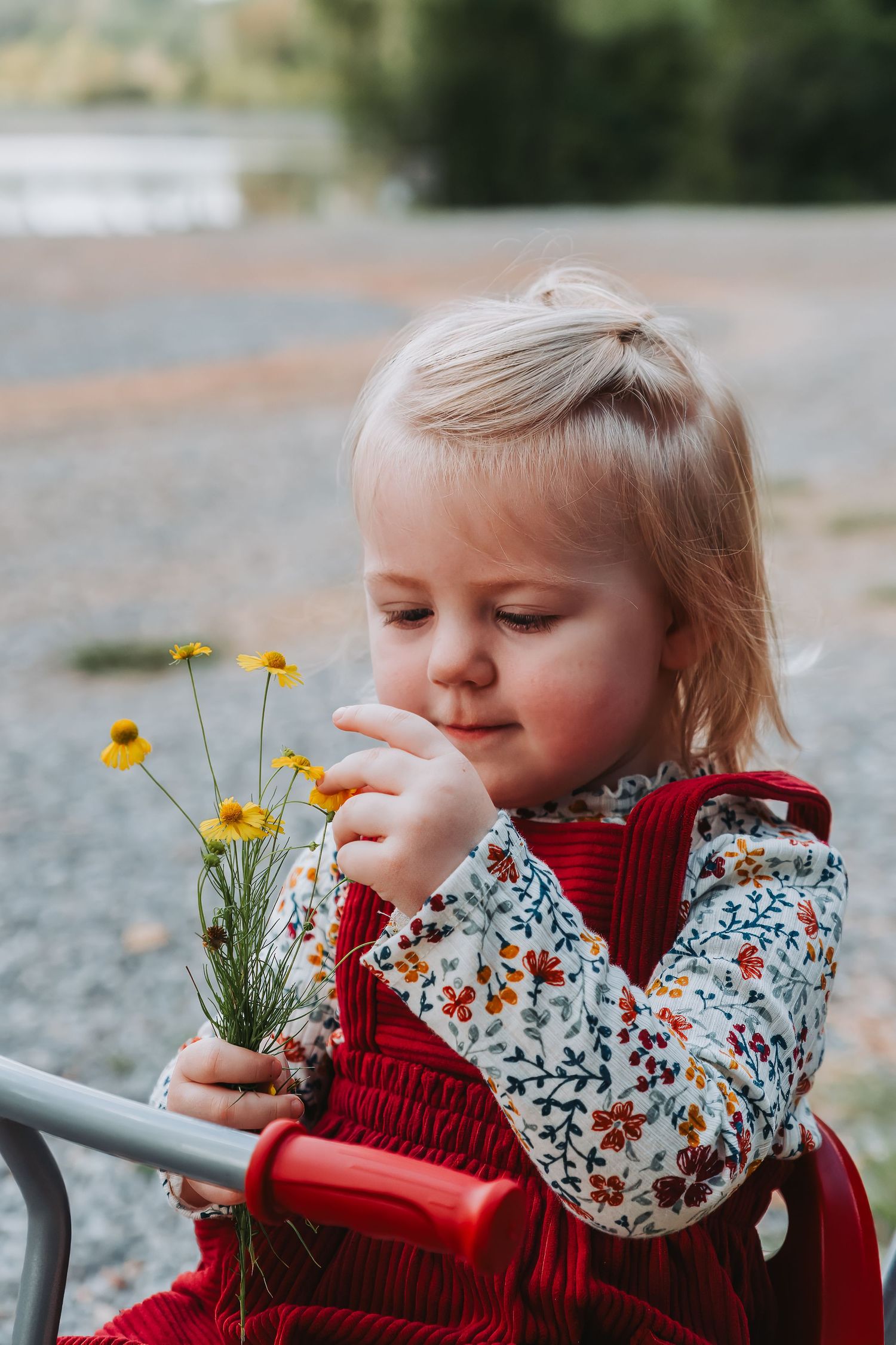 Young girl looking at and touching wild flowers she picked