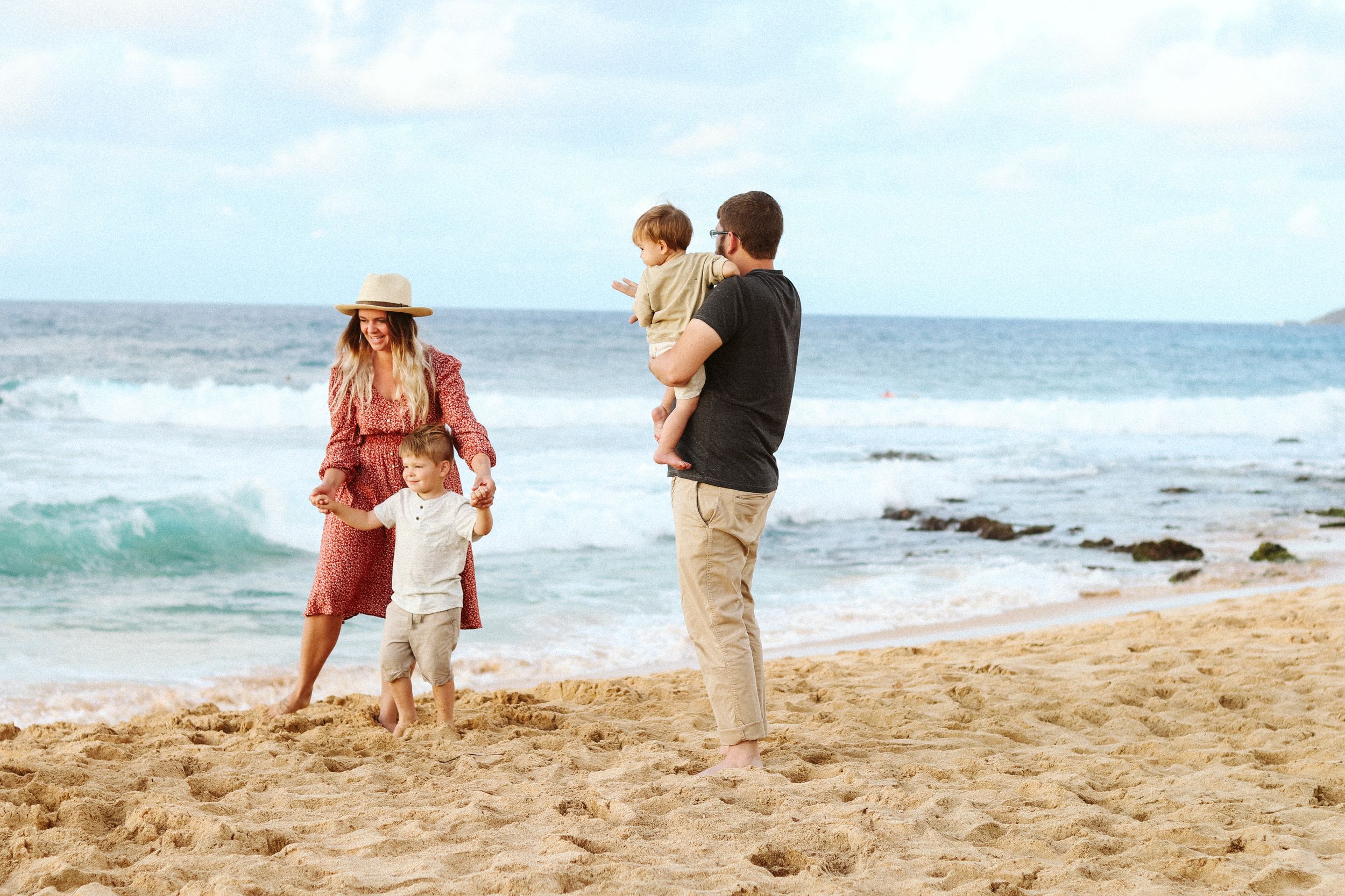 Family enjoys a playful afternoon together on a scenic Hawaiian beach.