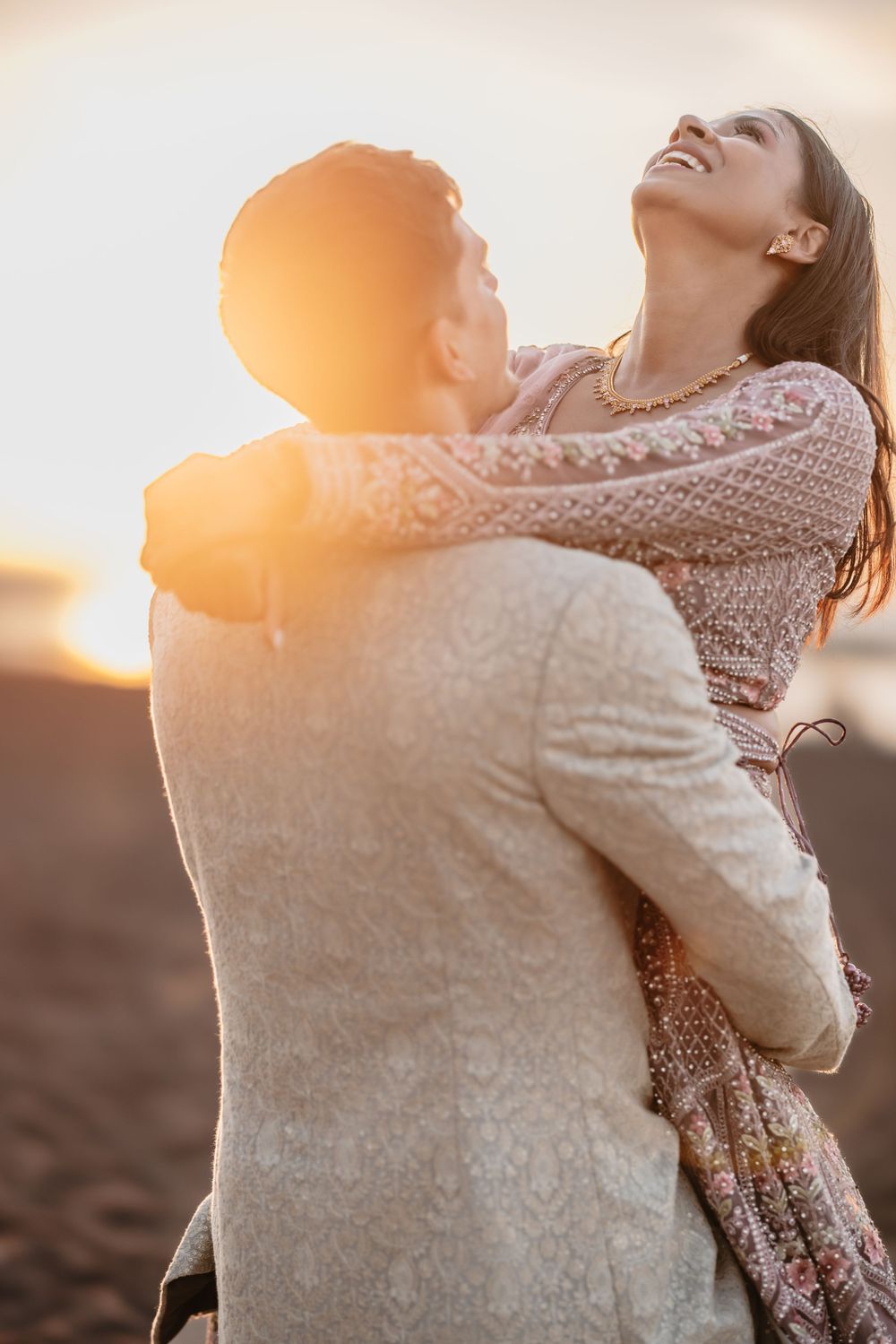 A romantic sunset silhouette of a couple embracing outdoors.