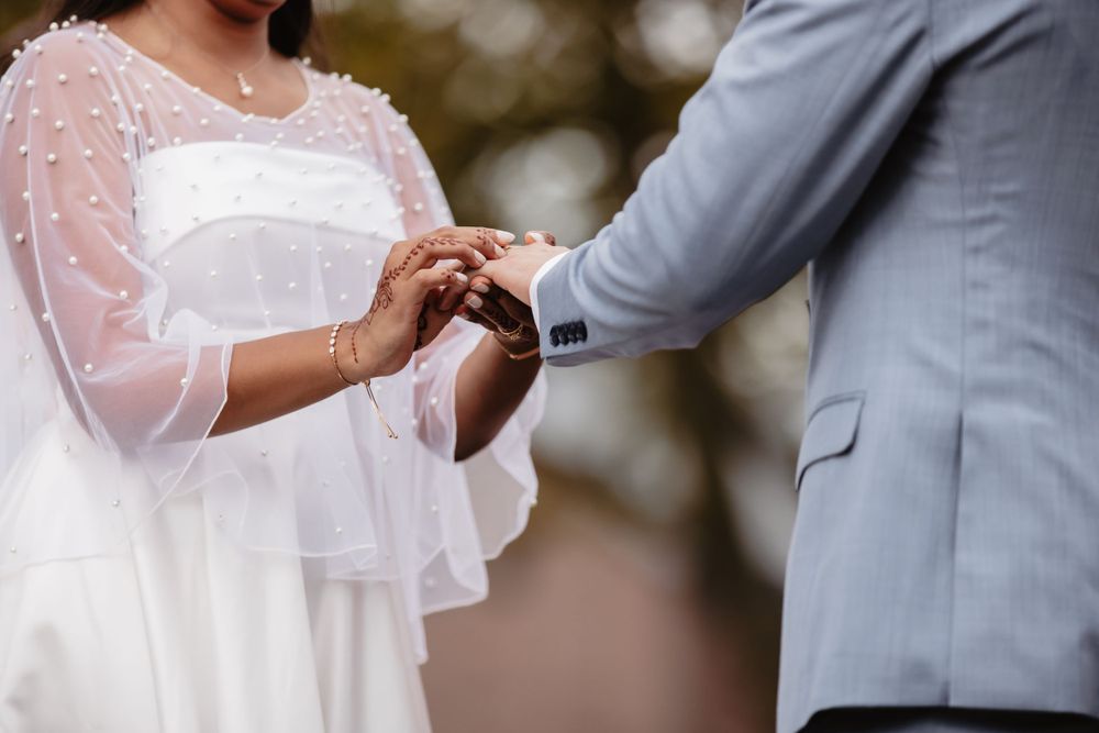 A couple shares a romantic moment in formal attire with delicate lace details.