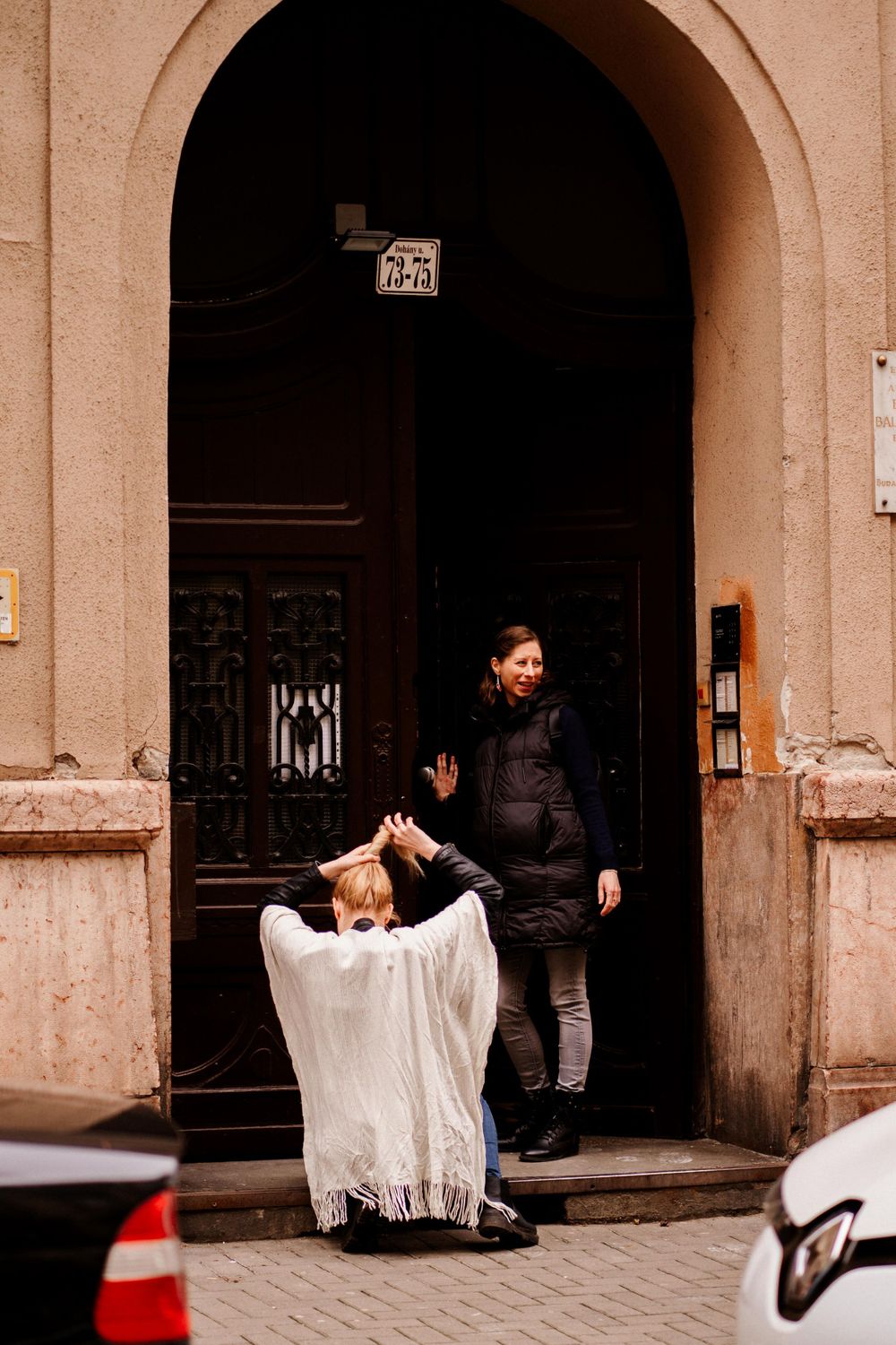 Artistic portrait of two people posing in a doorway of an old building.