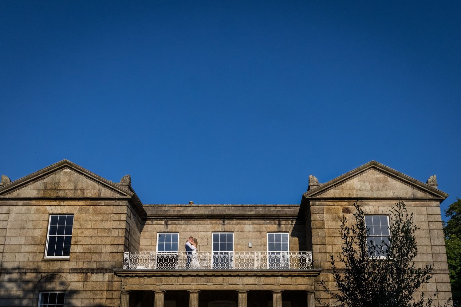 Elegant stone mansion facade with classic Georgian architectural features and symmetrical windows.