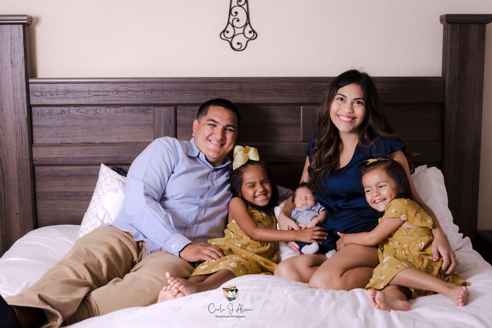 Happy family spending quality time together during indoor photoshoot on bed.