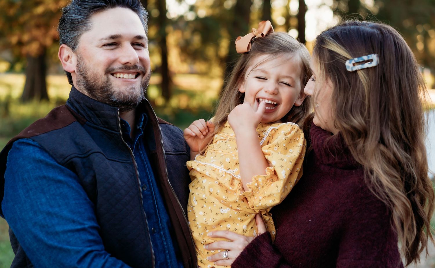 Happy family sharing a joyful moment together in autumn sunlight.